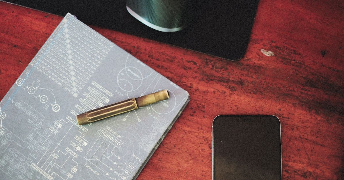 Escritorio de consultorio con agenda, teléfono y computadora encendida